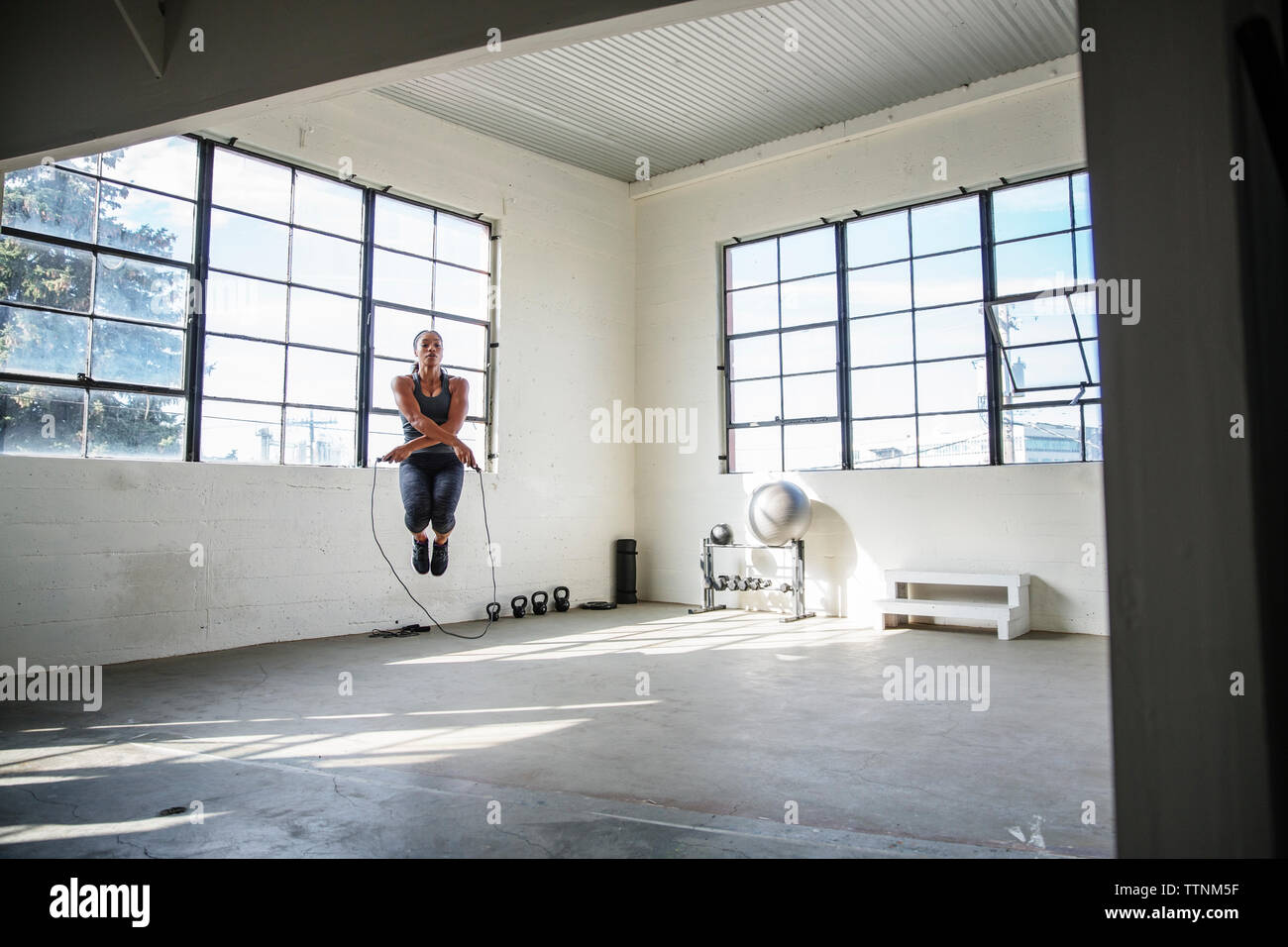 Weibliche Athleten überspringen mit Seil springen in der Turnhalle Stockfoto