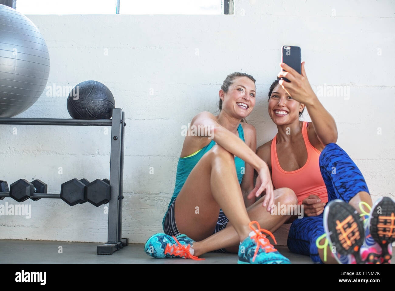 Gerne weibliche Freunde unter selfie durch Mobiltelefon in der Turnhalle Stockfoto