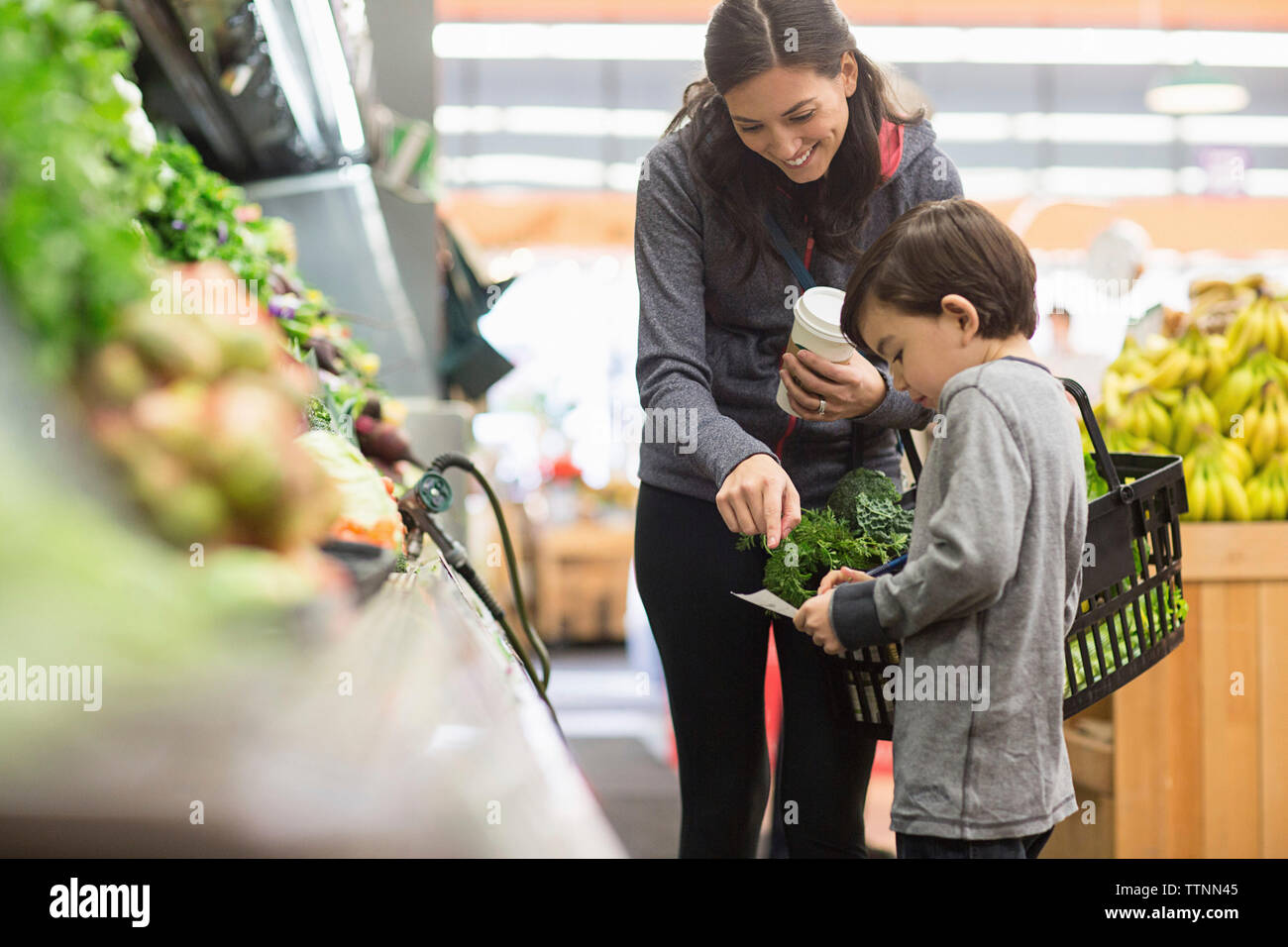 Mutter und Sohn auf die Merkliste beim Stehen durch die Regale im Supermarkt Stockfoto