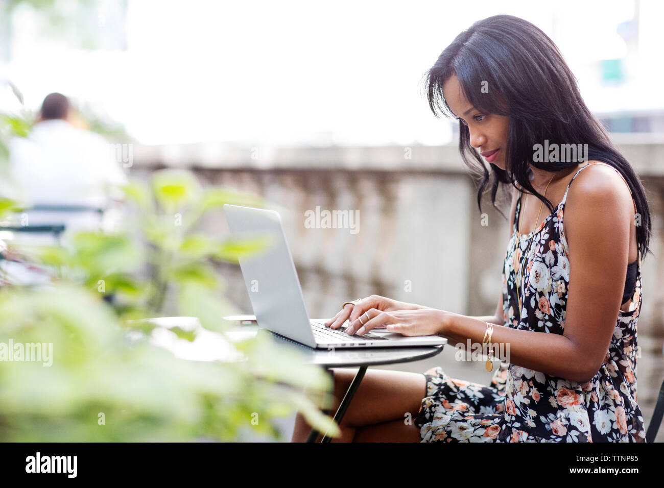 Konzentrierte sich Frau mit Laptop im Straßencafé Stockfoto
