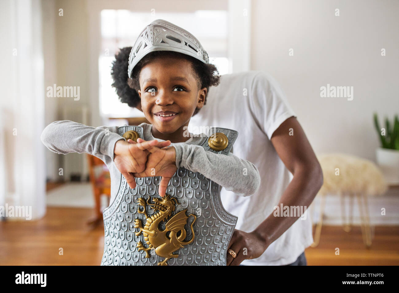 Vater Unterstützung fröhliche junge, als Rüstung gekleidet zu Hause Stockfoto