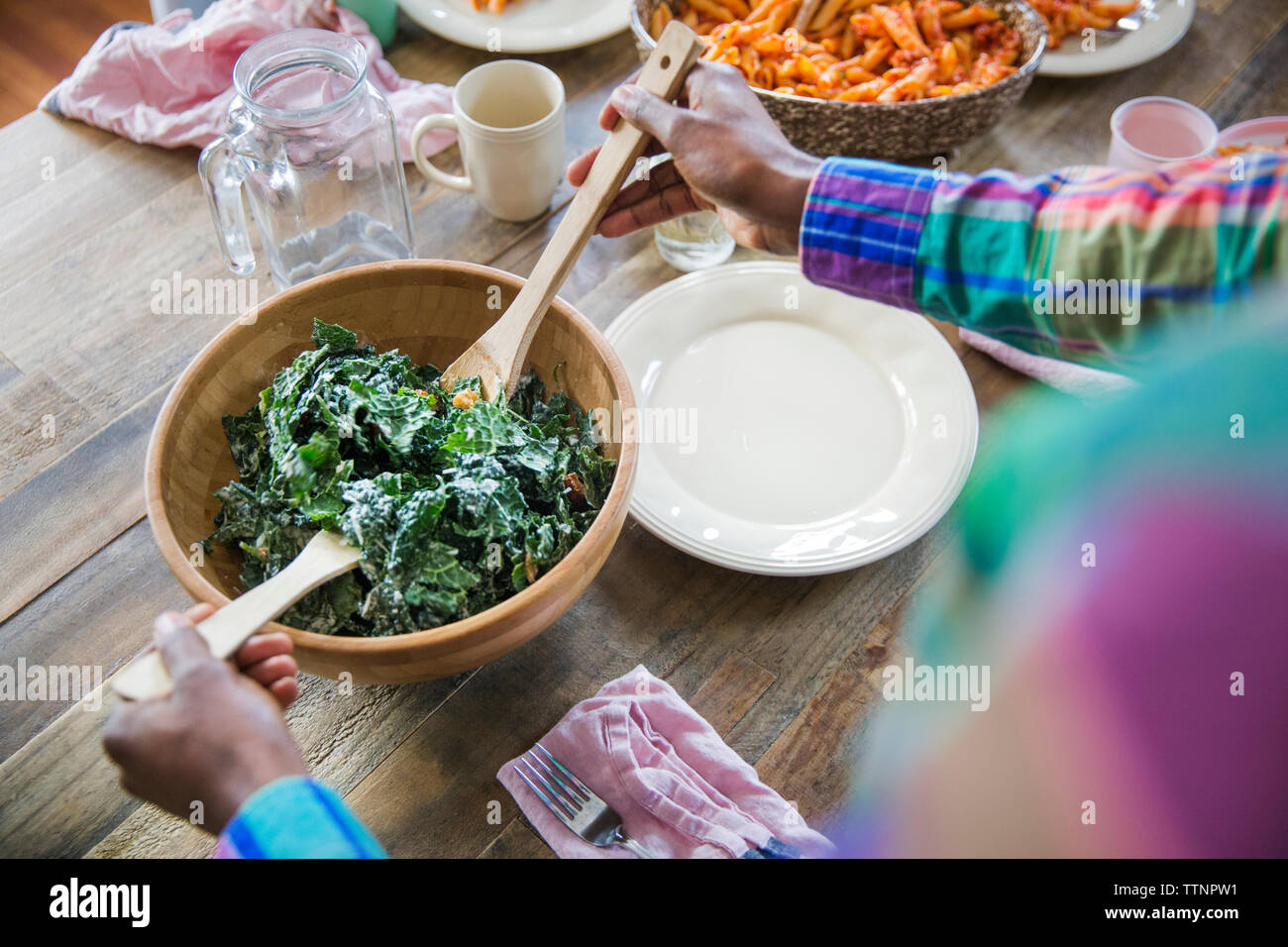 Draufsicht des Menschen frischen Salat an Esstisch serviert Stockfoto