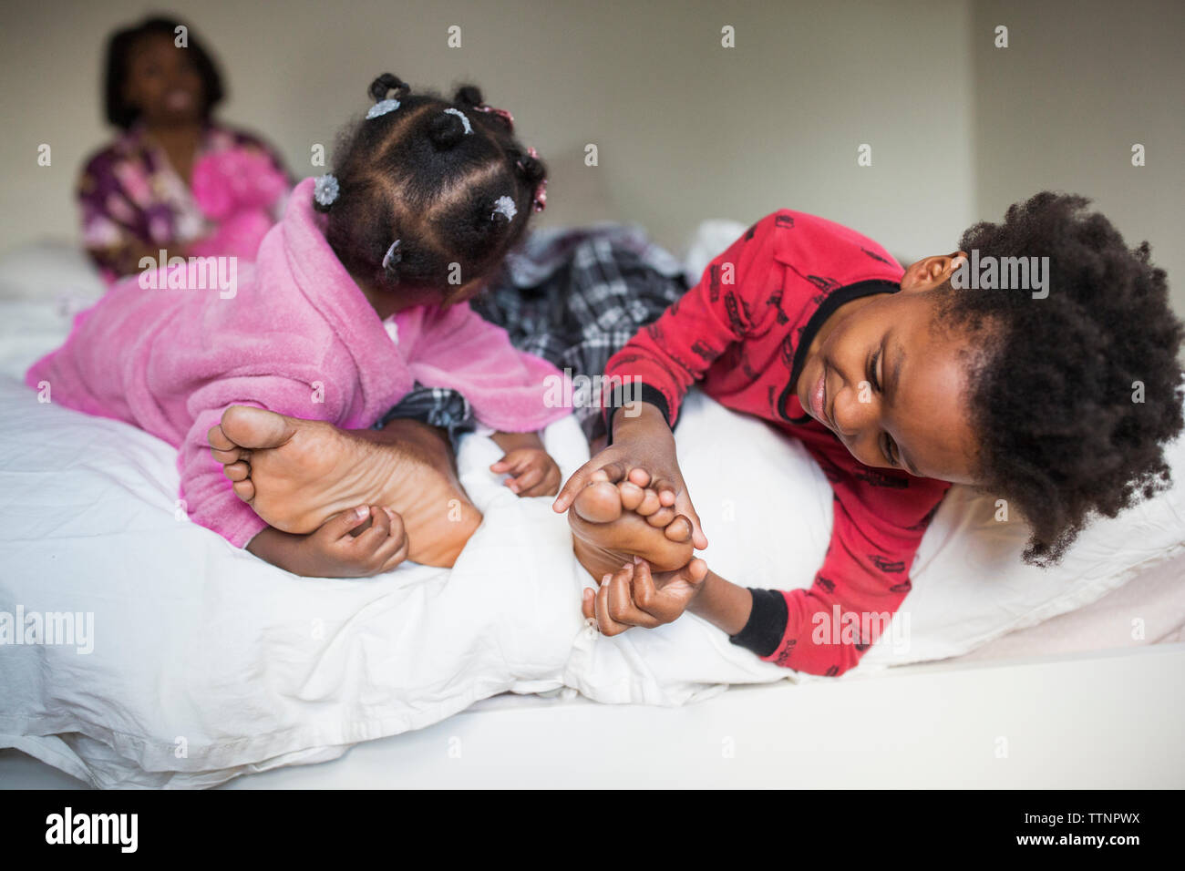 Kinder kitzeln's Vater Füße auf dem Bett Stockfoto