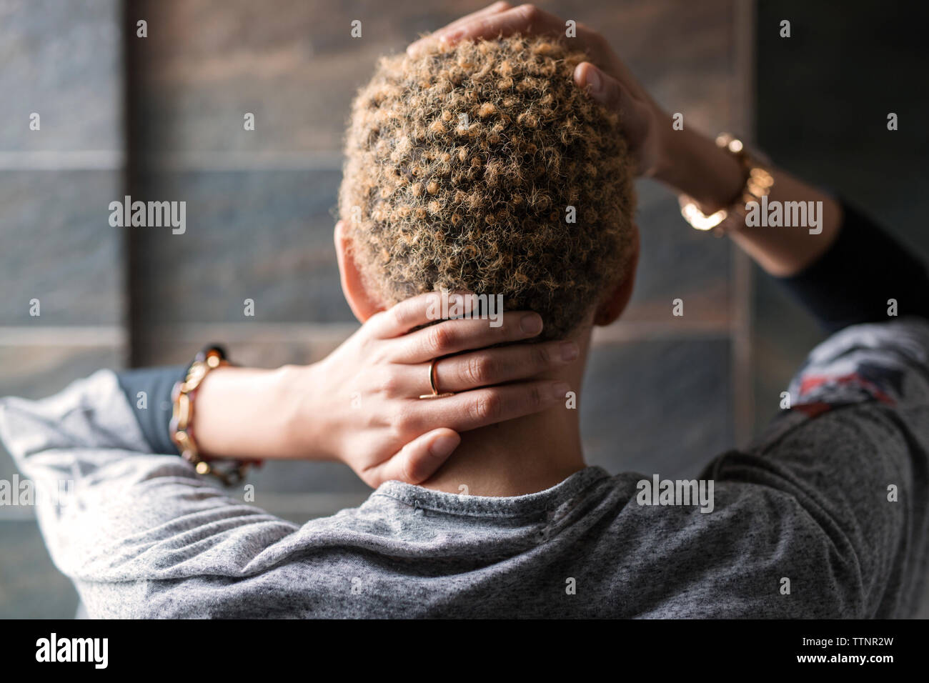 Ansicht der Rückseite Frau berühren Hals und Haar zu Hause Stockfoto