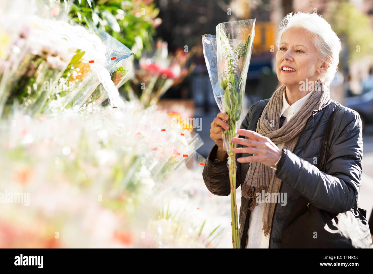 Ältere Frau Kaufende Blumen am Marktstand Stockfoto