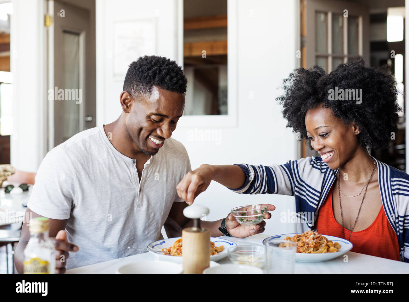 Glückliches Paar in Essen am Esstisch Stockfoto