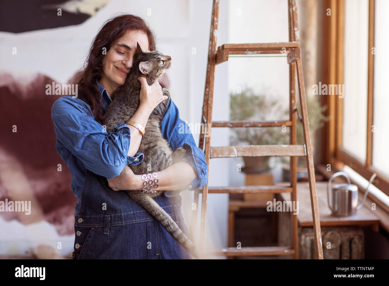 Lächelnd Künstler die Katze beim Stehen in der Werkstatt Stockfoto