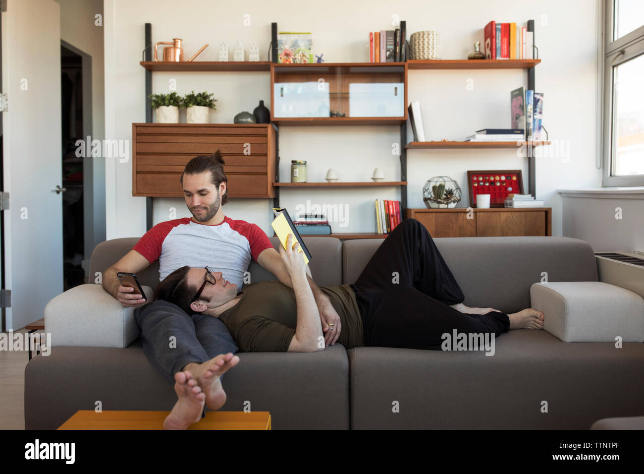 Homosexuelle Paare entspannt auf einem Sofa zu Hause Stockfoto