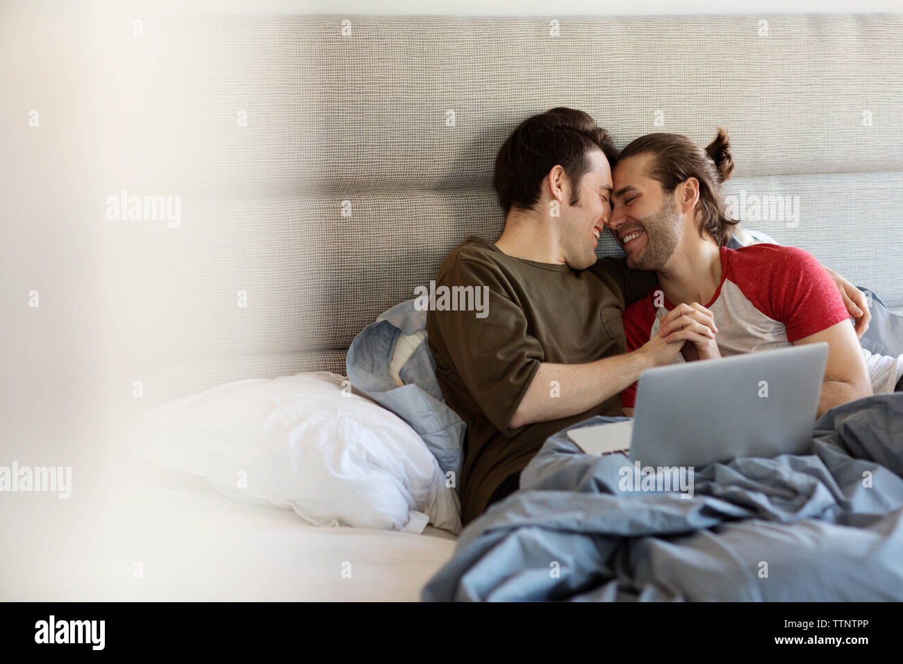 Glücklich homosexuelle Paare romancing auf Bett zu Hause Stockfoto
