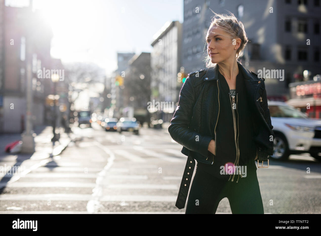 Frau mit Händen in den Taschen der Weg schauen beim Gehen auf die Straße der Stadt während der sonnigen Tag Stockfoto
