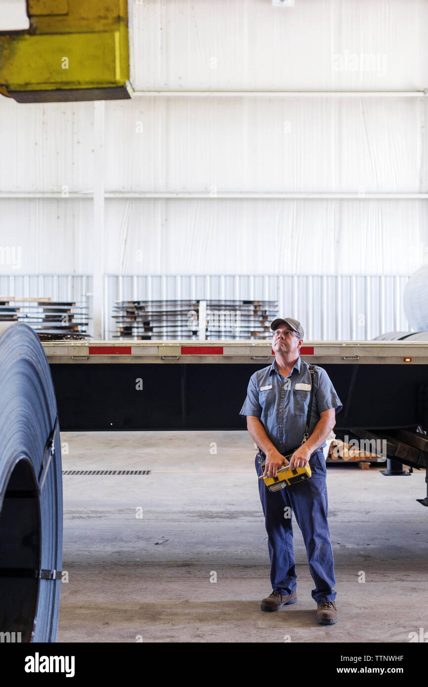 Volle Länge des Arbeitnehmers Maschinen bedienen und sah, während in der Metallverarbeitung Stahlwerk Stockfoto