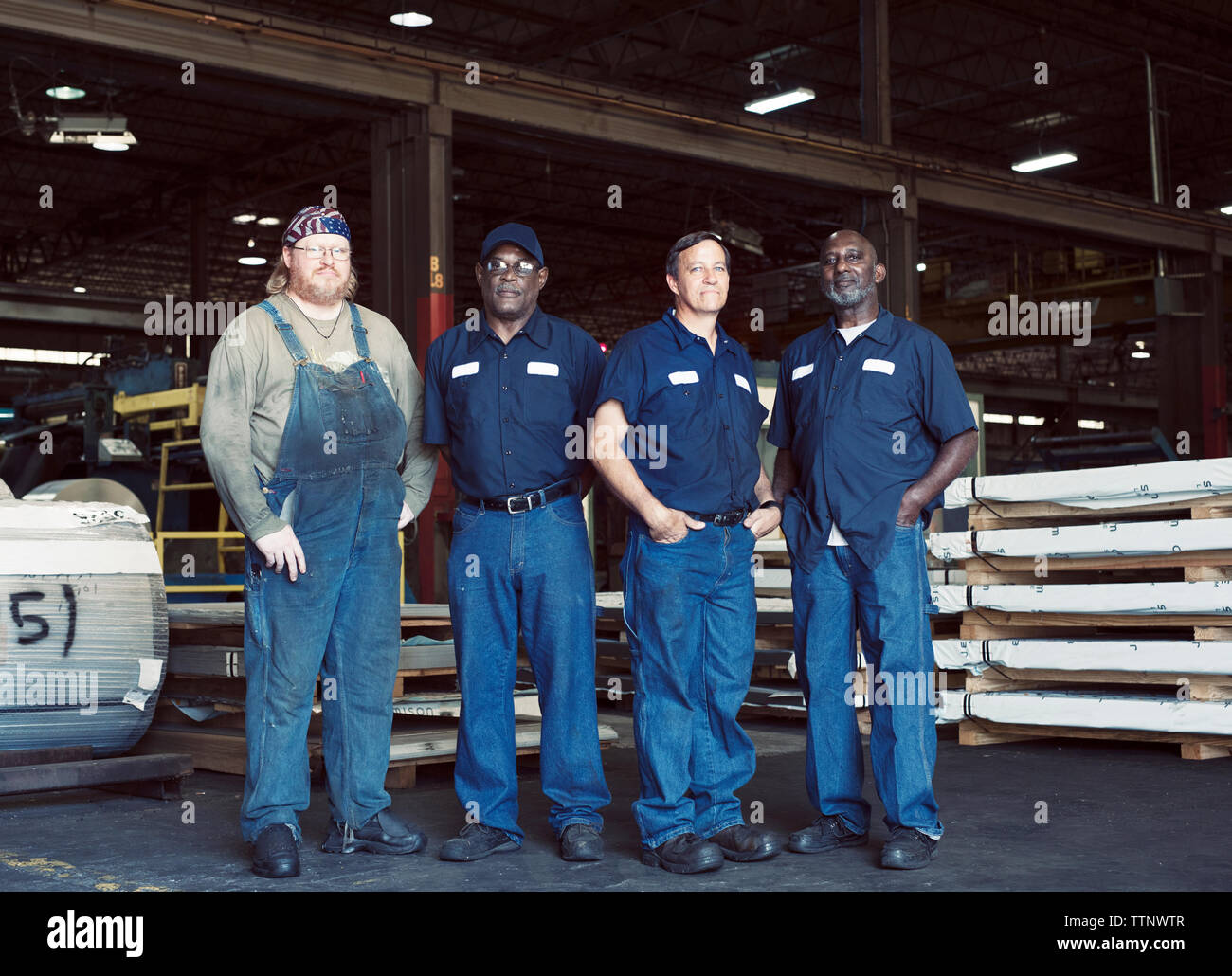 Volle Länge Portrait von Kollegen gegen die Herstellung von Objekten in der Industrie Stockfoto