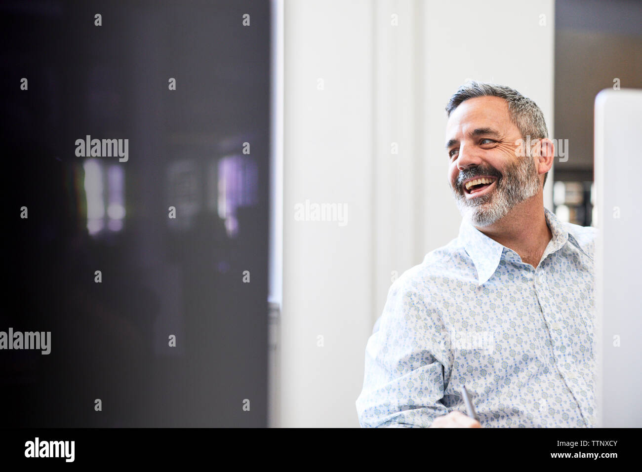 Fröhliche Geschäftsmann weg schauen und die Arbeit im Büro Stockfoto