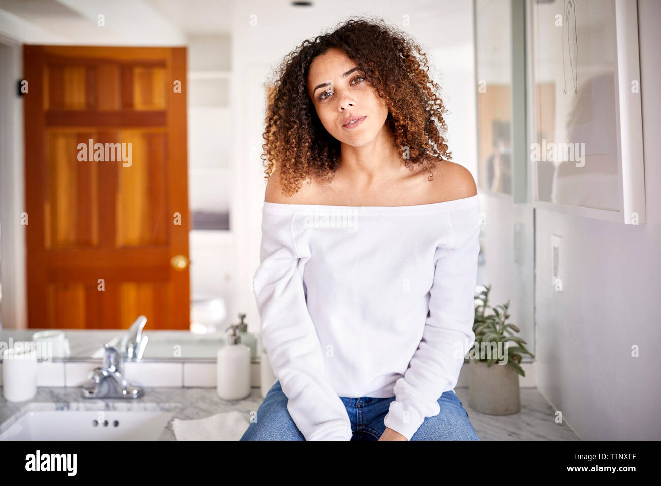 Portrait von Frau sitzt im Spiegel im Bad zu Hause Stockfoto