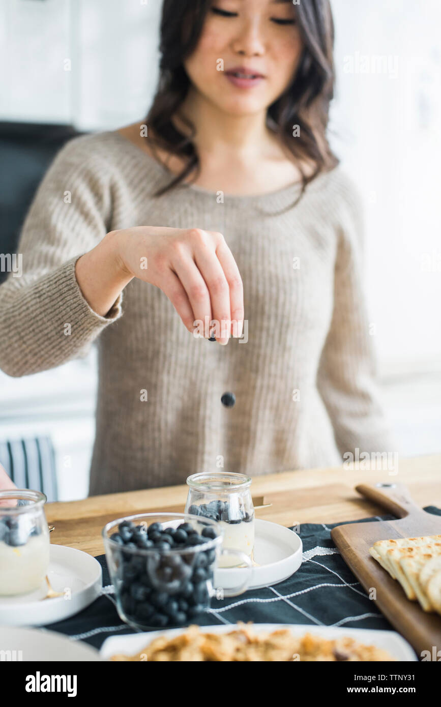 Frau Vorbereitung Frühstück am Tisch in der Küche Stockfoto