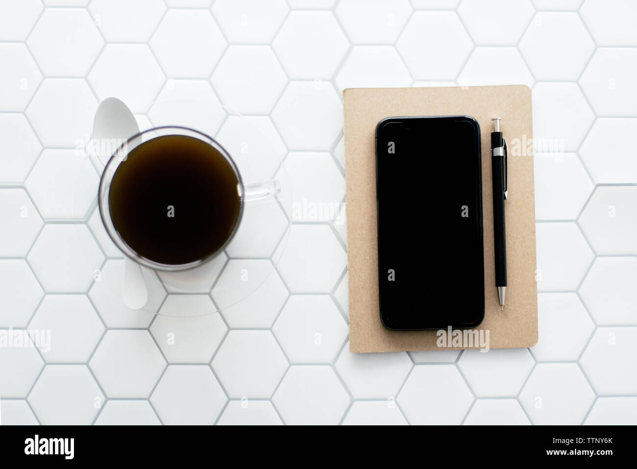 Flatlay-Notebook, Kaffee, Stift auf weißem Hexagon625 Stockfoto