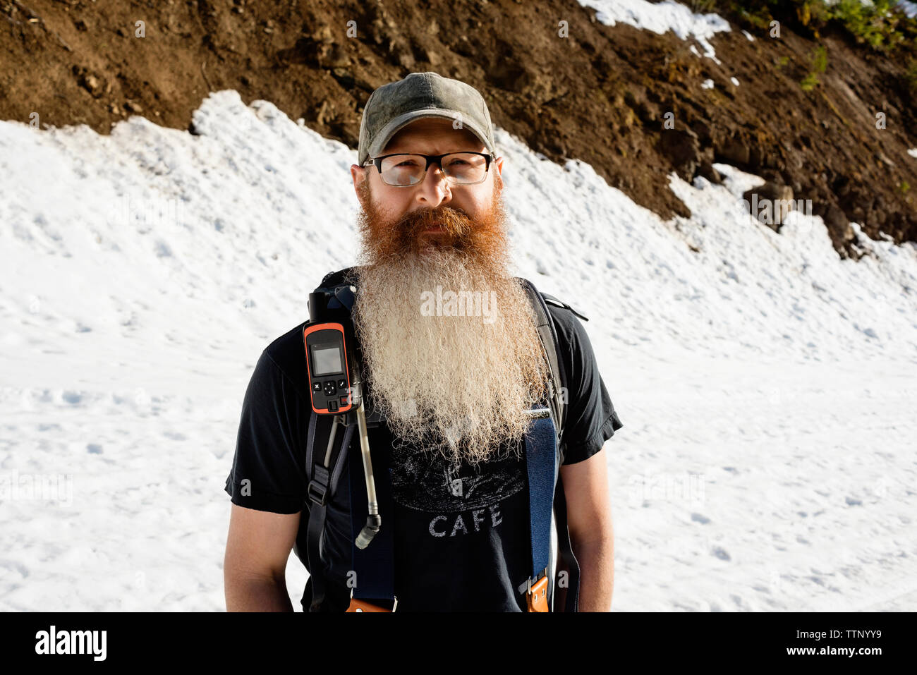Portrait von zuversichtlich Mann stand auf schneebedeckten Berg Stockfoto