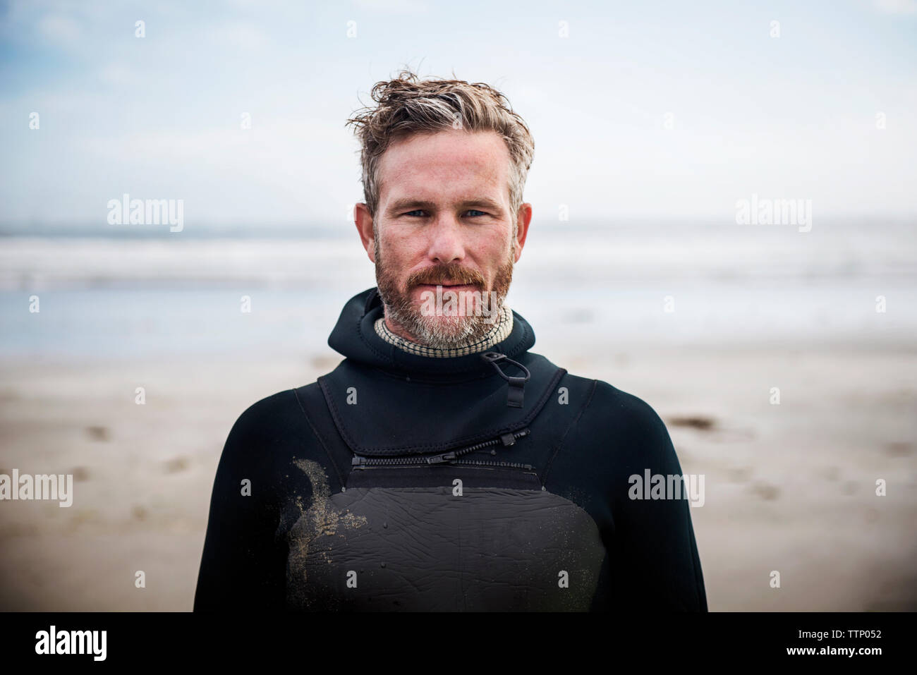 Portrait von zuversichtlich Surfer am Strand Stockfoto