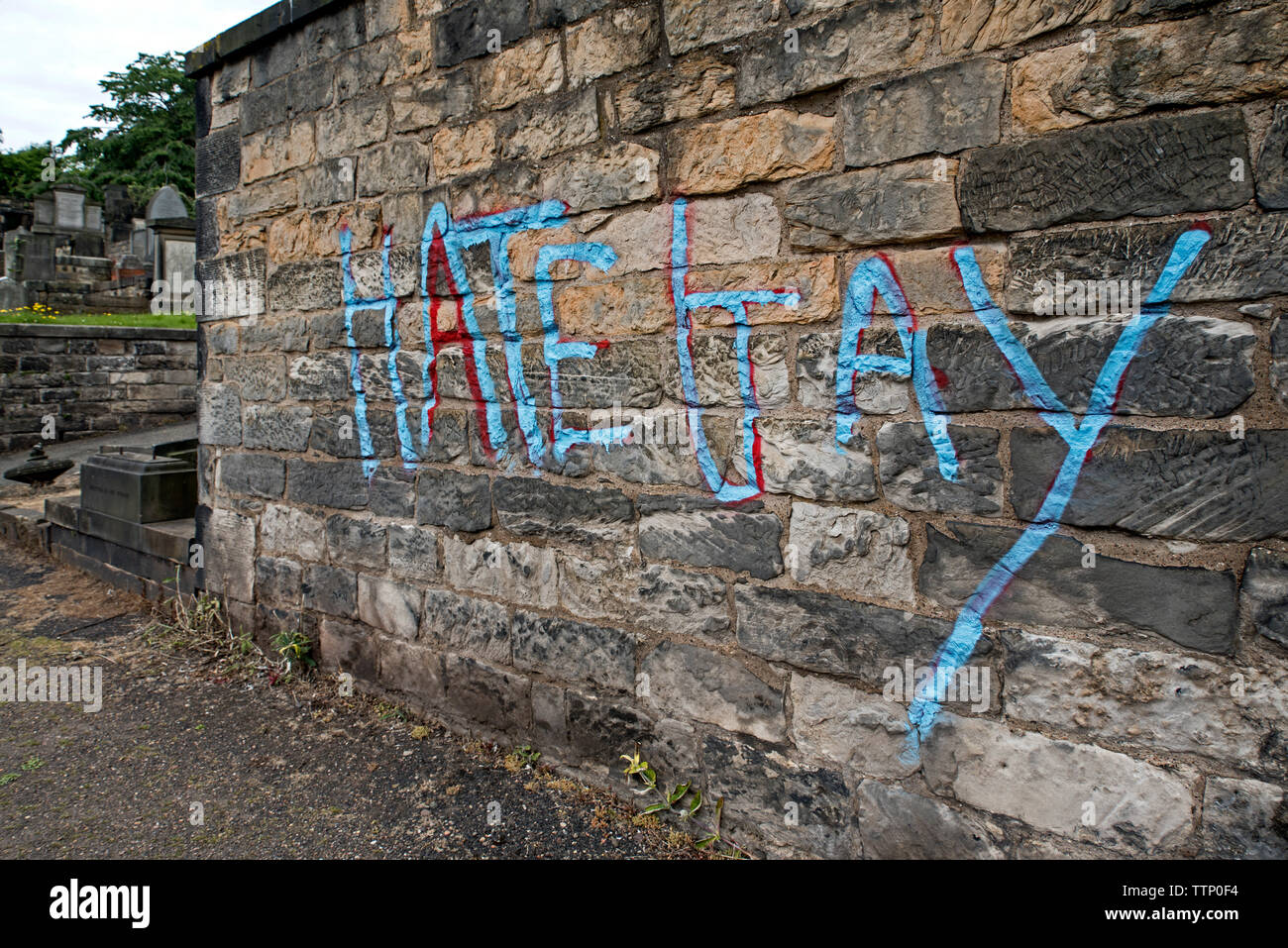 Homophobe graffiti auf Gräbern in neuen Calton Grabstätte, Edinburgh, Schottland, UK gemalt. Juni 2019. Stockfoto