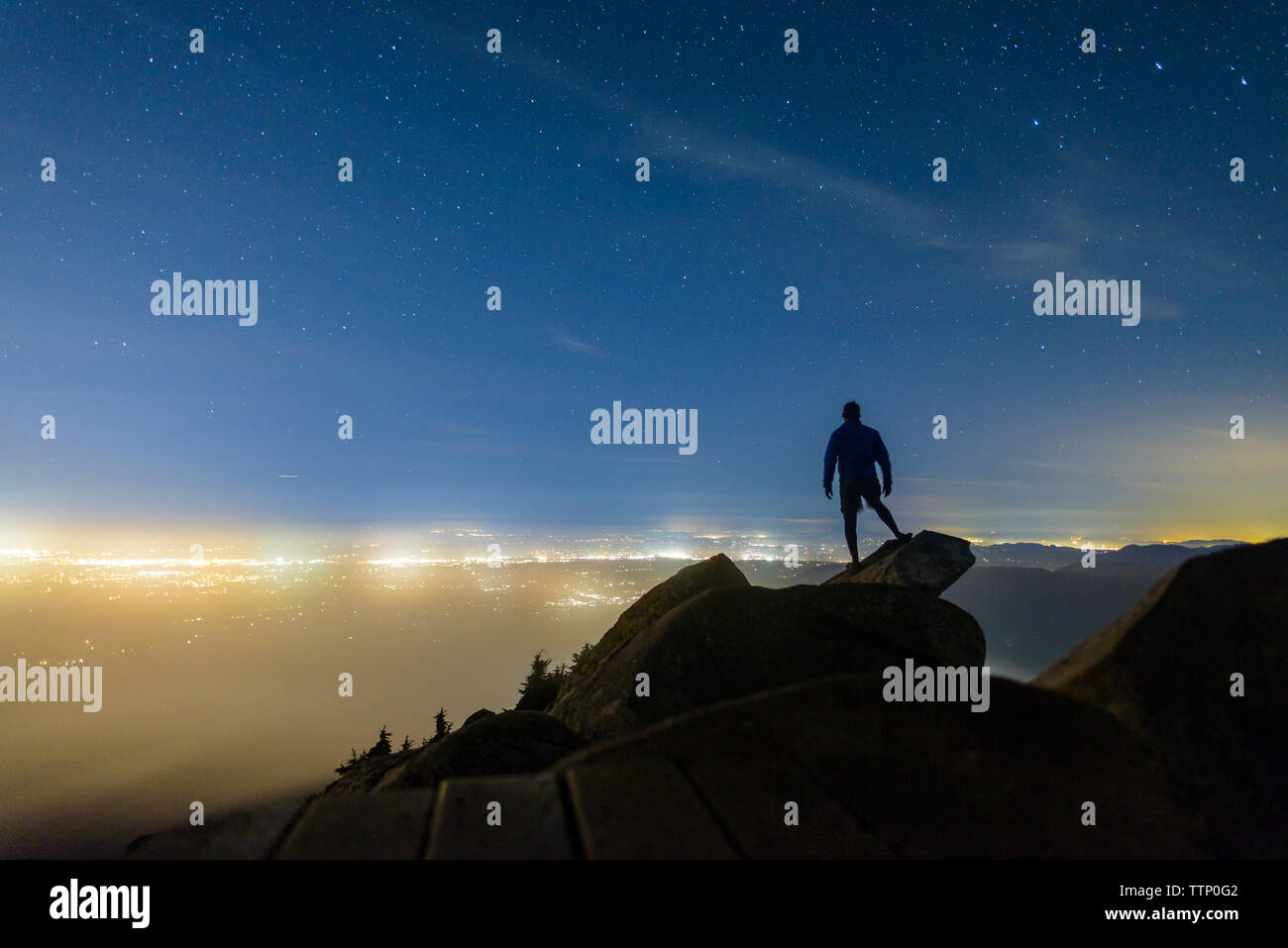 Silhouette Mann stand auf Felsen gegen star Feld am Mount Pilchuck State Park bei Nacht Stockfoto