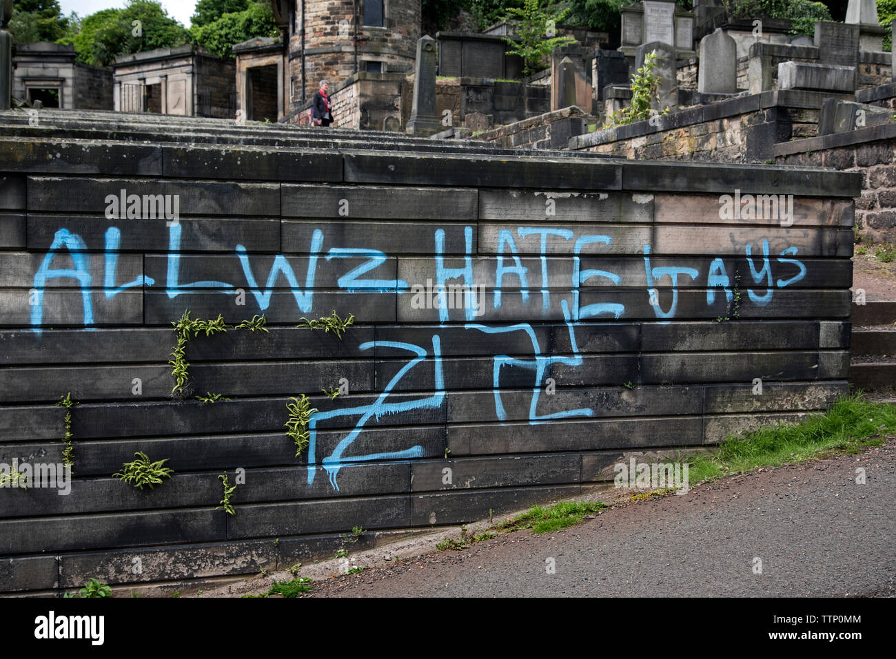 Hakenkreuze und homophoben Graffiti auf Gräbern in neuen Calton Grabstätte, Edinburgh, Schottland, UK gemalt. Juni 2019. Stockfoto