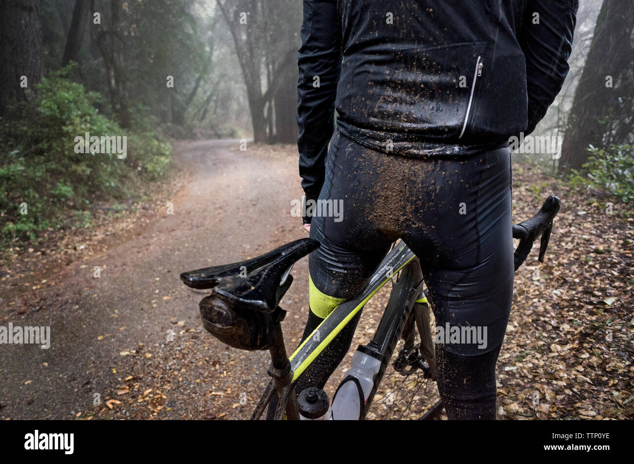 Auf Mann reiten Fahrrad auf nasser Straße Schmutz Stockfoto
