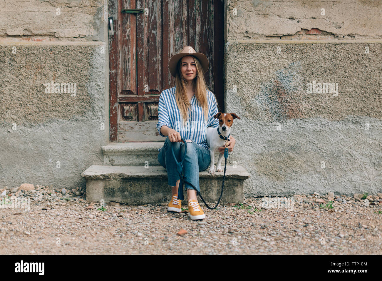 Portrait von Frau mit Jack Russell Terrier sitzt auf der vorderen Stoop Stockfoto