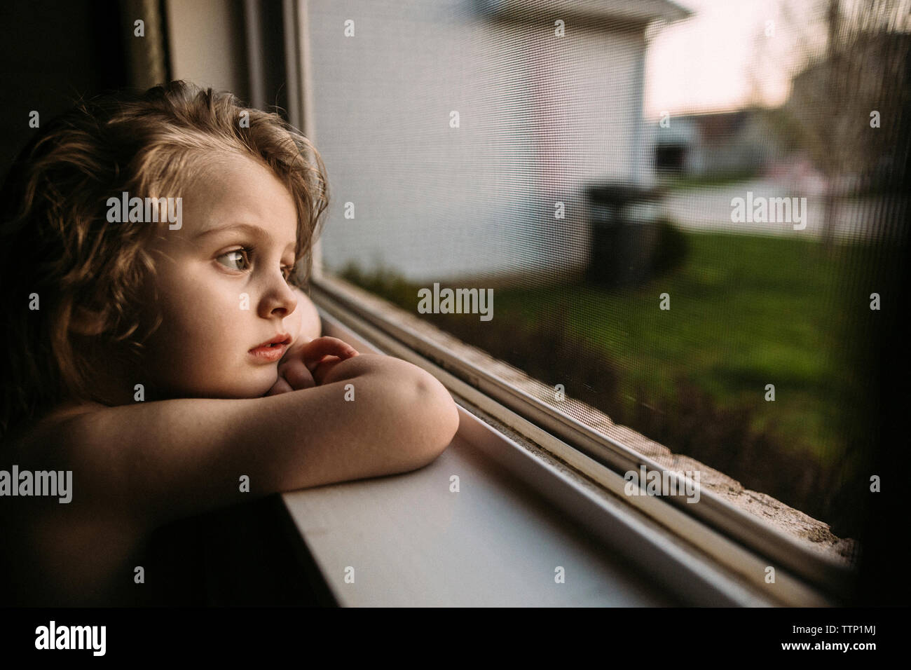 Nachdenkliches Mädchen weg schauen und lehnte sich auf Fensterbank Stockfoto