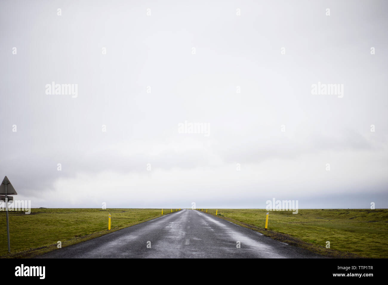 Country Road inmitten von Feld gegen Sky Stockfoto