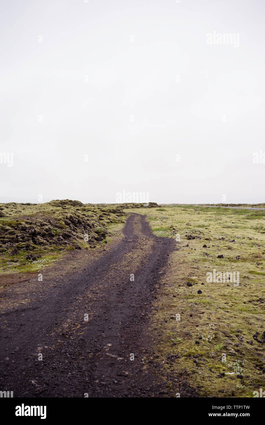 Schmutz der Straße am Feld gegen Sky Stockfoto
