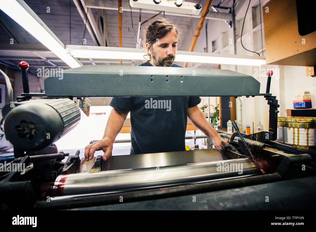 Männliche Arbeitnehmer mittels Druck Maschine in der Werkstatt Stockfoto