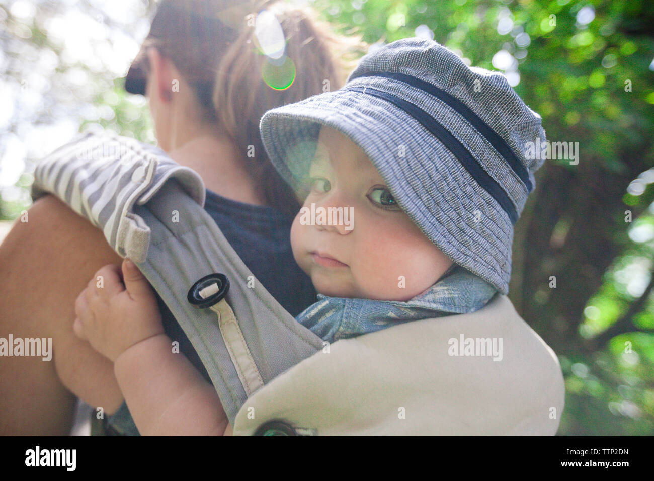 Porträt des Sohnes durch die Mutter in der Babyschale im Wald durchgeführt werden Stockfoto