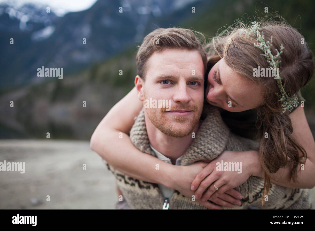 Portrait von Freund und Freundin ihn umarmen gegen Berge Stockfoto