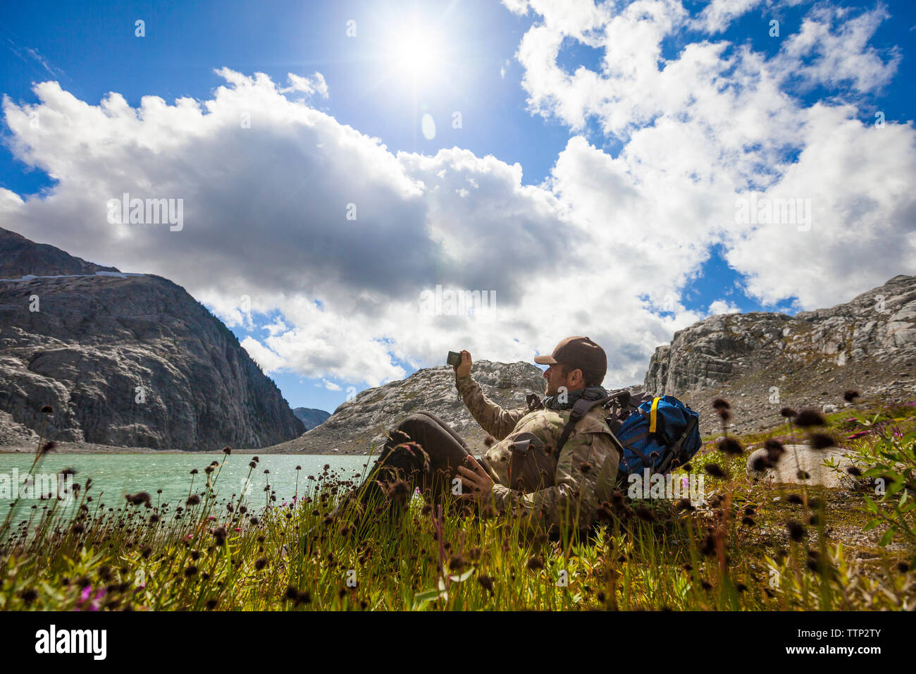 Seitenansicht der Wanderer fotografieren beim Entspannen auf See gegen Sky Stockfoto