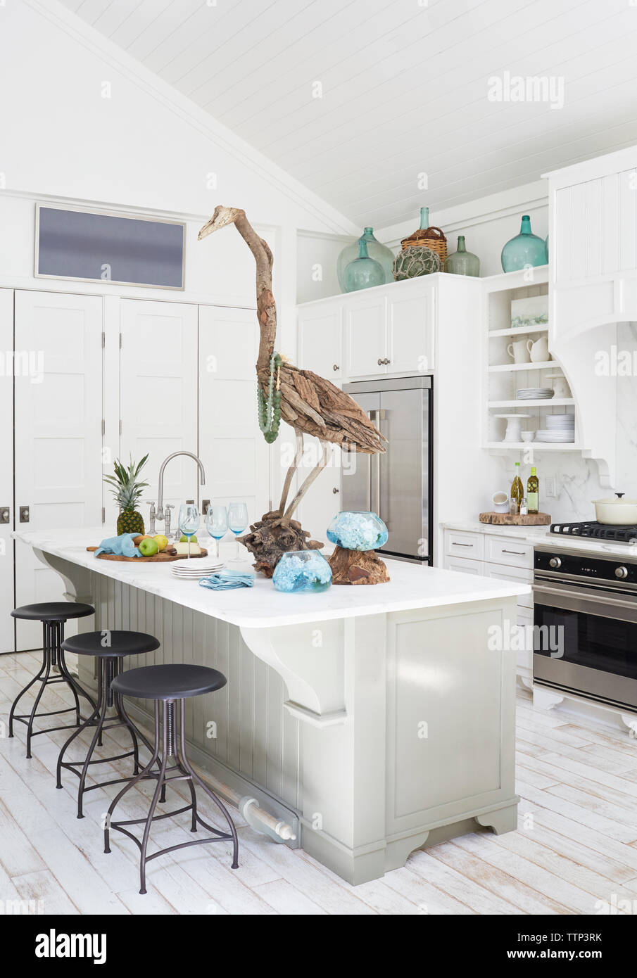 Holz- Vogel Skulptur am Esstisch in der Küche im Cottage Stockfoto