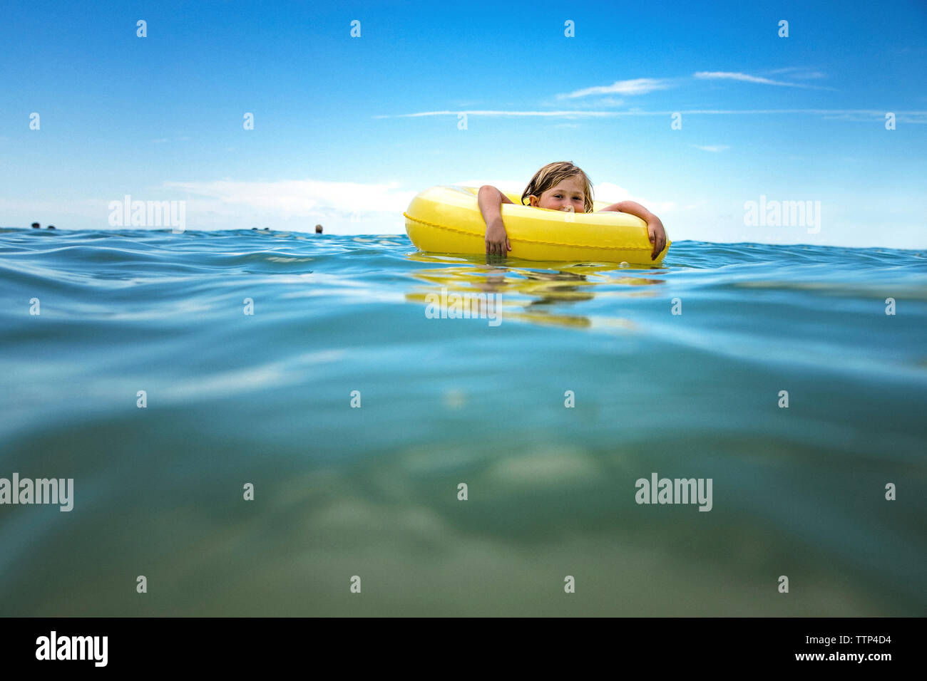 Portrait von Mädchen im inneren Rohr schwimmend auf Meer gegen Sky Stockfoto