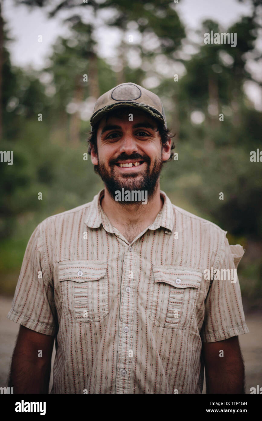 Portrait von lächelnden Mann mit Kappe im Wald Stockfoto