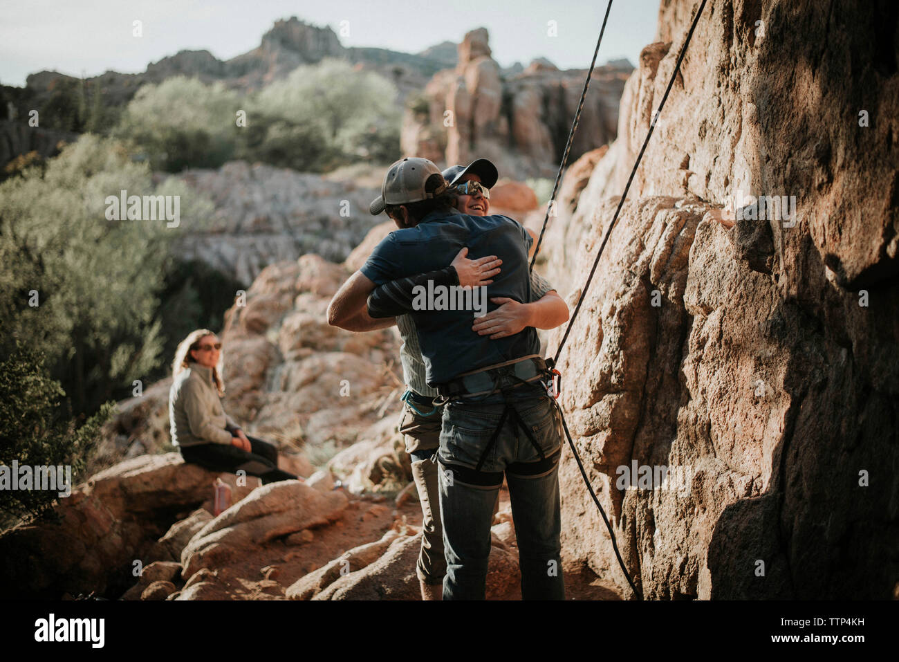 Frau auf der Suche nach männliche Freunde umarmen auf Felsen im Red Rock Canyon National Conservation Area Stockfoto