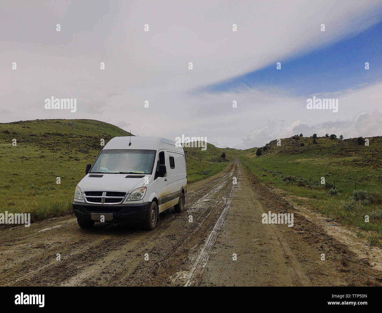 Motor home über unbefestigte Straße inmitten der Hügel gegen bewölkter Himmel geparkt Stockfoto