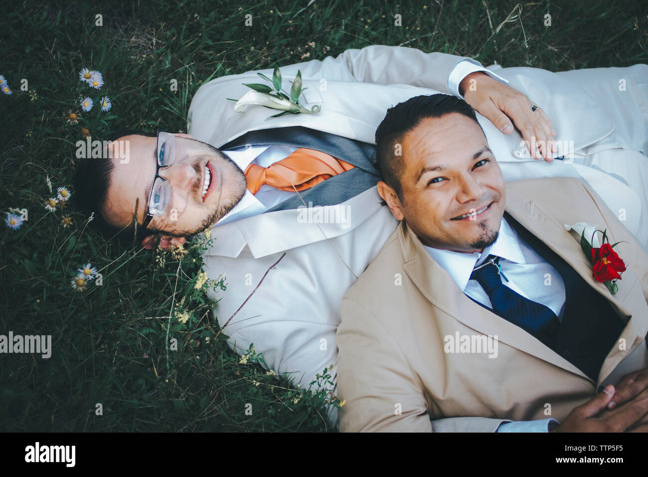 Portrait von glücklich homosexuelle Paare liegend auf der Wiese Stockfoto