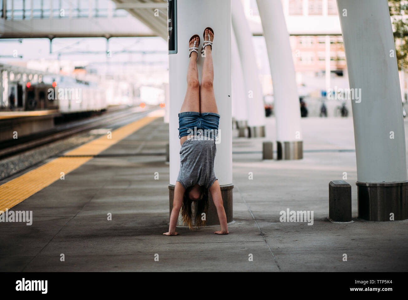 Mädchen tun handstand am Bahnhof Plattform Stockfoto