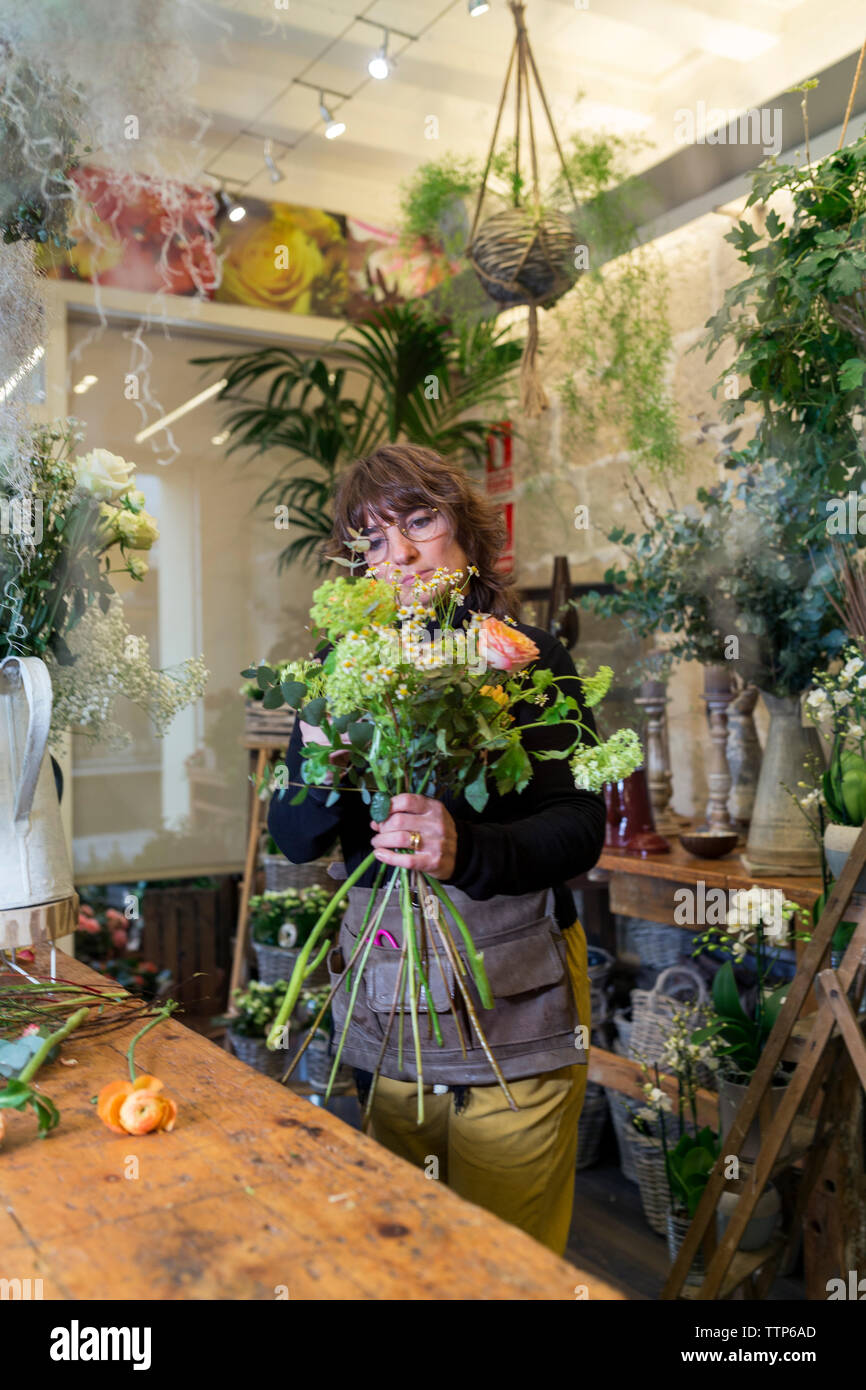 Ältere Frau Vorbereitung Blumenstrauß im Flower Shop Schreibtisch Stockfoto
