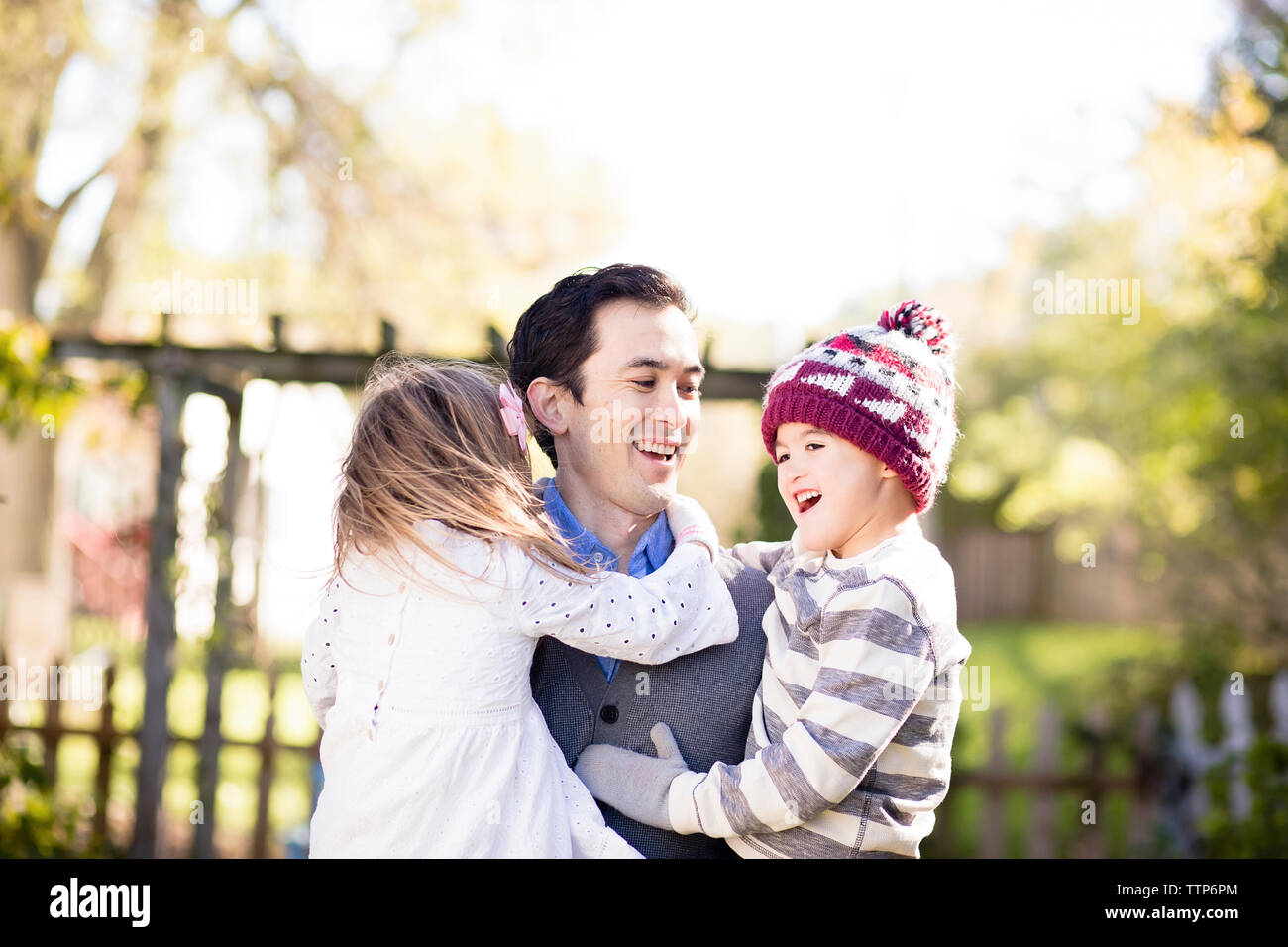 Gerne Vater Kinder tragen beim Stehen gegen Himmel im Hof Stockfoto