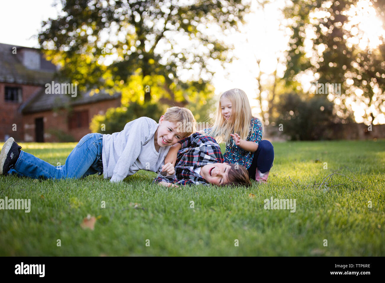 Geschwister Lachen und Spielen im Freien in Wiese Stockfoto