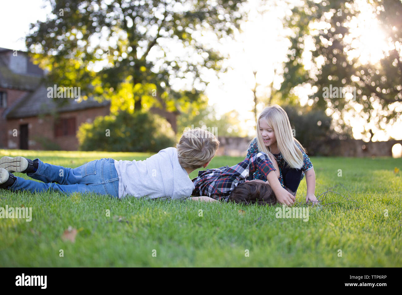 Kinder Geschwister zusammen draußen spielen in der Wiese Stockfoto