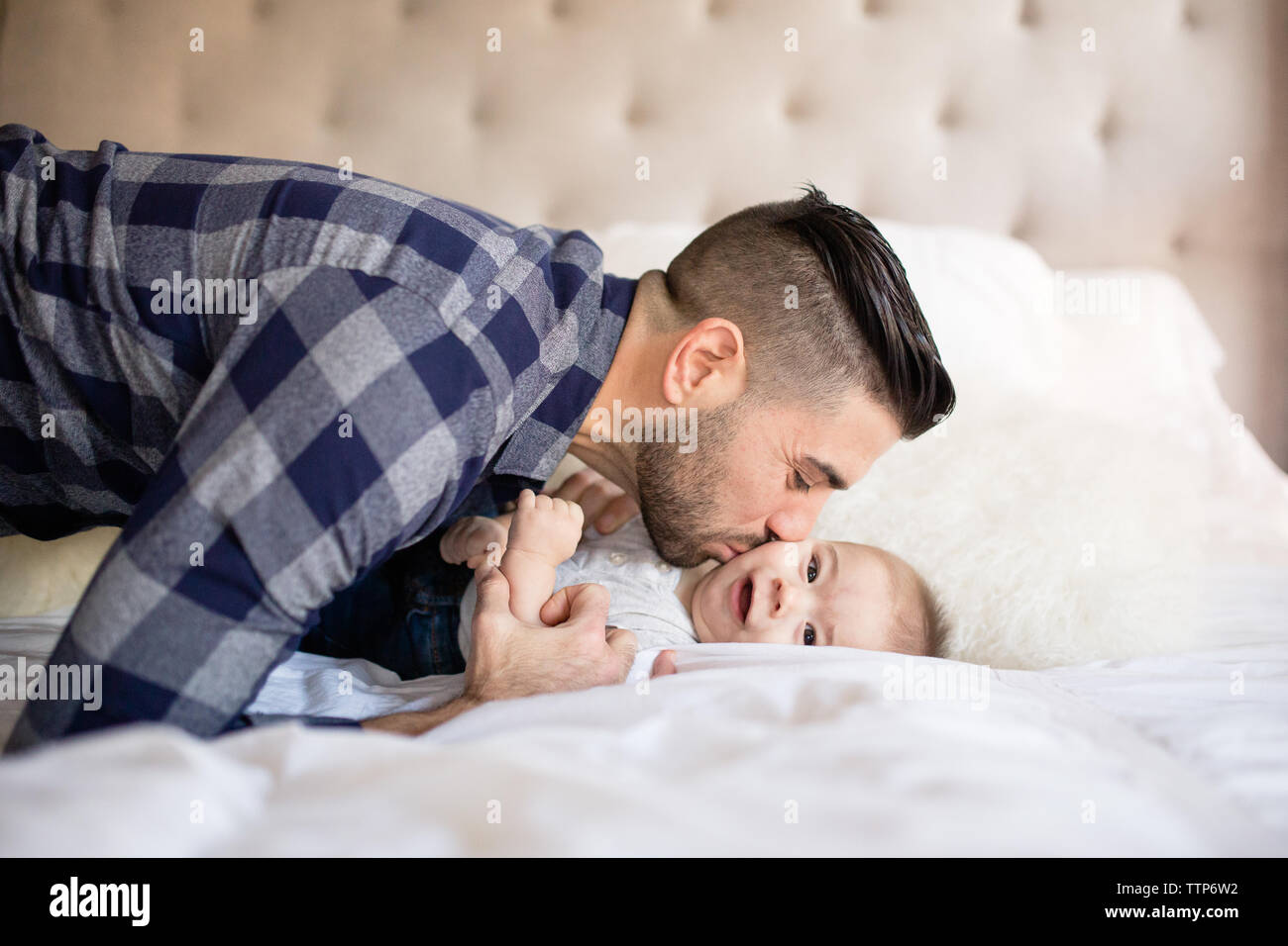 Seitenansicht des Papa küssen Cute Baby auf die Wange innen Stockfoto