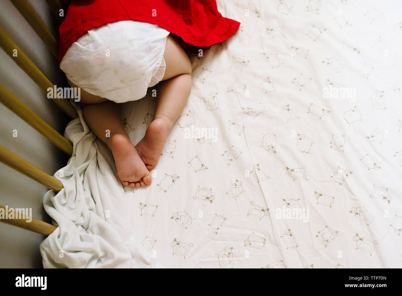 Niedrige Abschnitt von Toddler Knien auf dem Bett Stockfoto