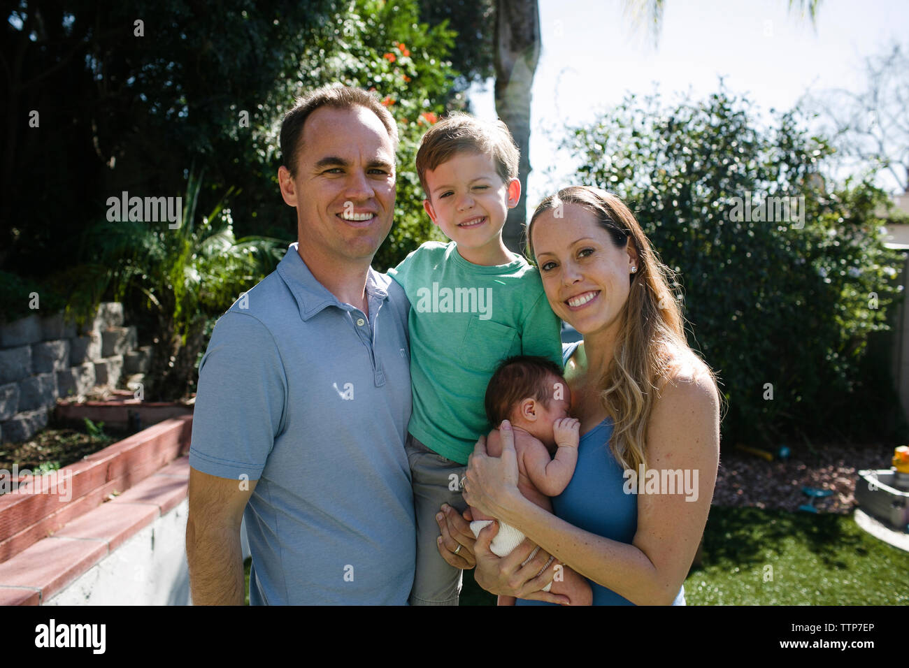 Portrait von glücklichen Eltern mit Kindern stehen im Hof Stockfoto