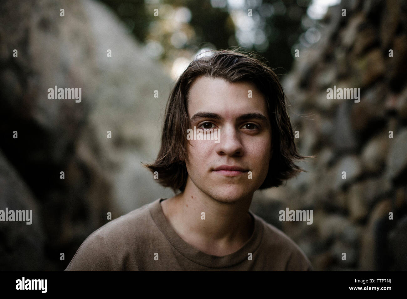 Close-up Portrait von stattlicher Mann gegen Felsformationen im Park sitzen Stockfoto
