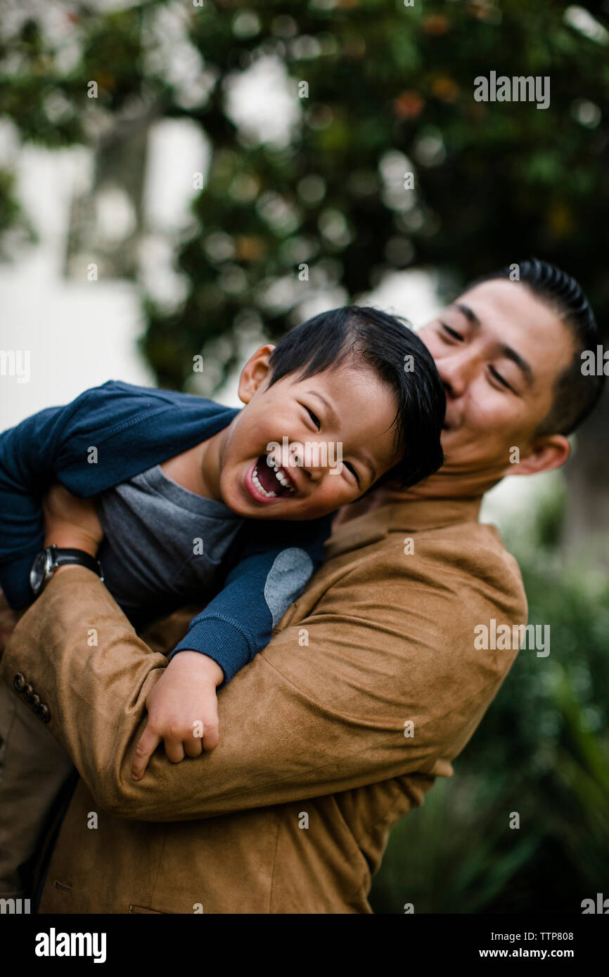 Low Angle View von Vater, Sohn glücklich beim Stehen gegen Bäume im Balboa Park Stockfoto